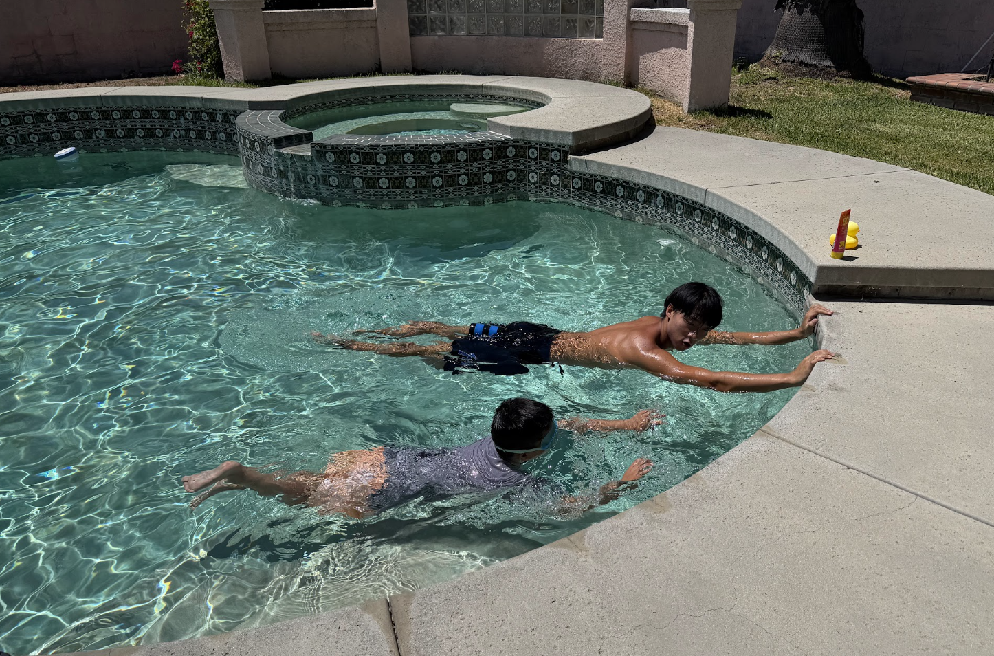 Two swimmers practicing prone floating and kick drills